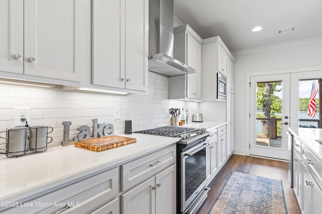 20 Heart Pine Ln, Dadeville, AL 36853 - kitchen featuring wall chimney range hood, stainless steel appliances, light countertops, dark wood-style floors, and crown molding