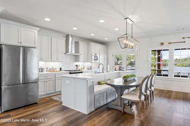 20 Heart Pine Ln, Dadeville, AL 36853 - kitchen with stainless steel appliances, wall chimney exhaust hood, light countertops, tasteful backsplash, and an island with sink