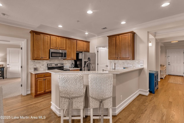 48 Stoneview Summit Ct Unit 2401, Dadeville, AL 36853 - kitchen with stainless steel appliances, crown molding, brown cabinets, light countertops, and light wood-style floors