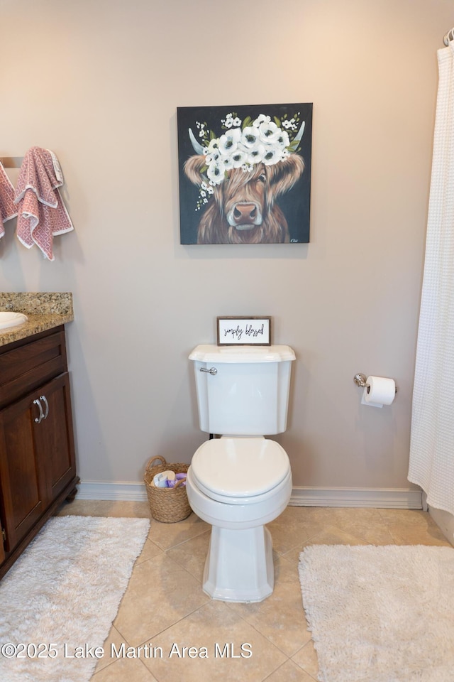 bathroom with tile patterned floors, baseboards, vanity, and toilet