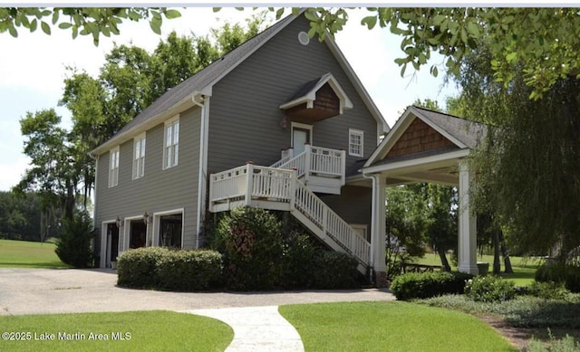 view of front facade with a garage, a front lawn, stairway, and concrete driveway