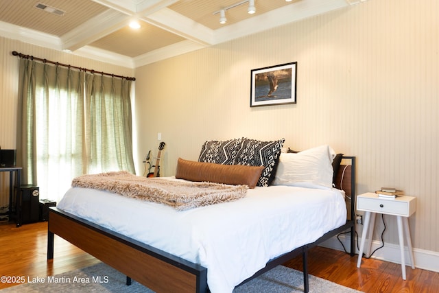 bedroom with visible vents, ornamental molding, wood finished floors, and beam ceiling