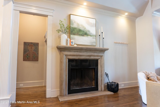 interior details featuring a fireplace with raised hearth, baseboards, and wood finished floors