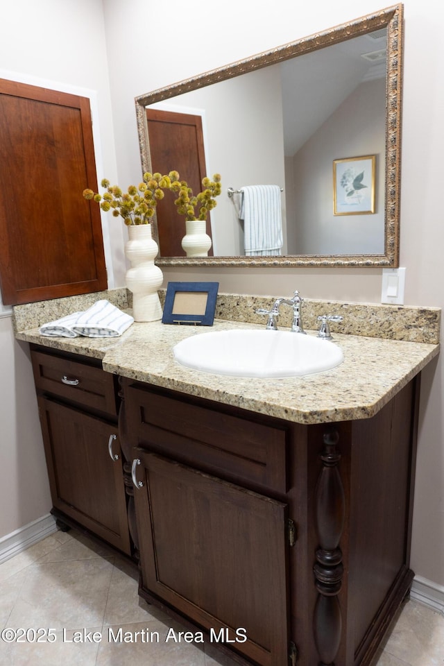 bathroom with vanity, baseboards, and tile patterned flooring