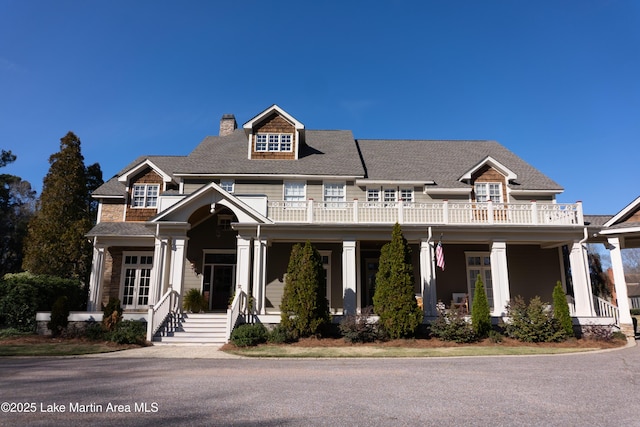 view of front of home with french doors, a balcony, and a chimney