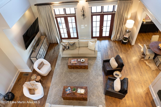 living area featuring french doors, baseboards, wood finished floors, and visible vents