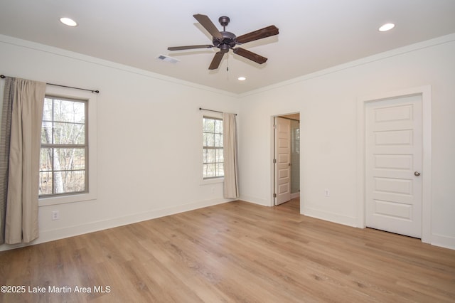 unfurnished bedroom with light wood-style floors, ornamental molding, and multiple windows