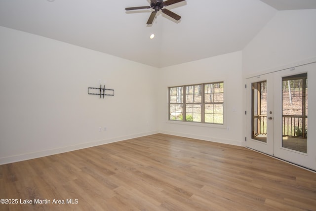 unfurnished room featuring high vaulted ceiling, light wood-style flooring, baseboards, and a ceiling fan