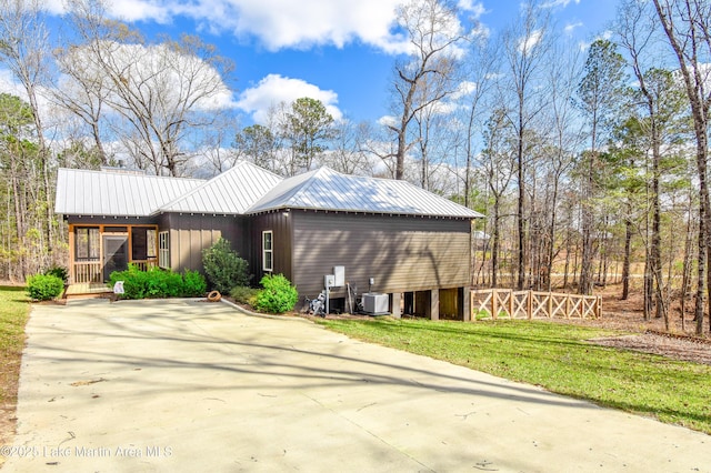 view of home's exterior featuring metal roof and a lawn