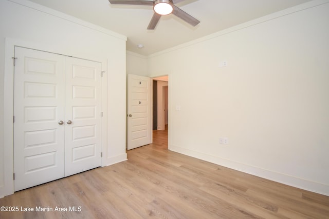 unfurnished bedroom with ornamental molding, baseboards, a closet, and light wood-style floors
