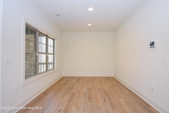 spare room featuring recessed lighting, light wood finished floors, baseboards, and ornamental molding