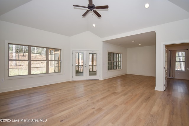 unfurnished living room with light wood-style flooring, a ceiling fan, baseboards, and lofted ceiling