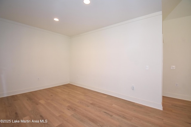 spare room with light wood finished floors, baseboards, ornamental molding, and recessed lighting