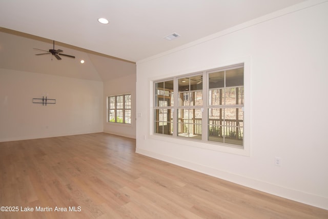 spare room featuring light wood-style floors, ceiling fan, visible vents, lofted ceiling, and baseboards