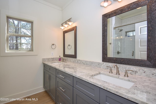 full bath featuring a shower stall, wood finished floors, double vanity, and a sink
