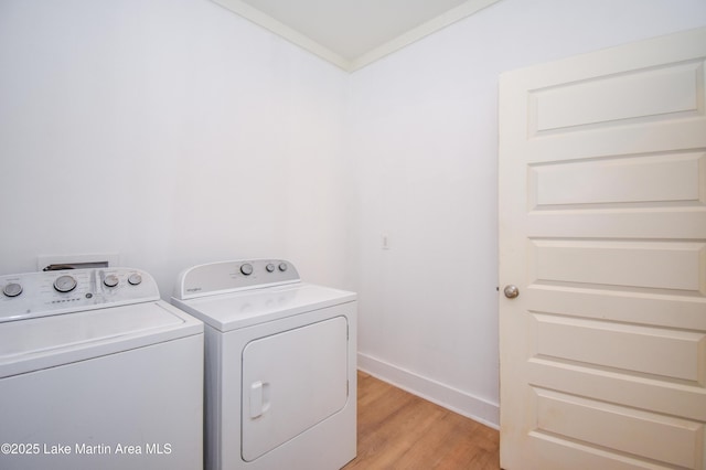 laundry room featuring independent washer and dryer, light wood-style floors, laundry area, and baseboards