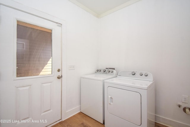laundry area featuring independent washer and dryer, laundry area, light wood finished floors, and baseboards