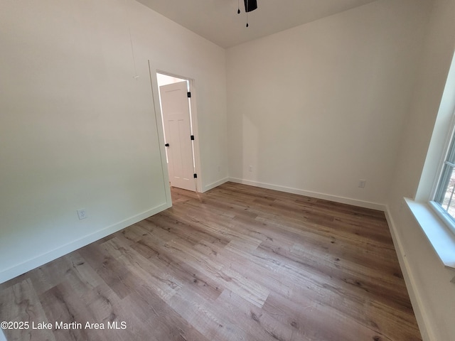 empty room with baseboards, a ceiling fan, and wood finished floors