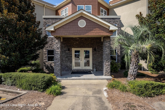 view of exterior entry with french doors and a porch