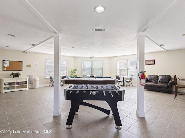 rec room featuring tile patterned floors and a textured ceiling