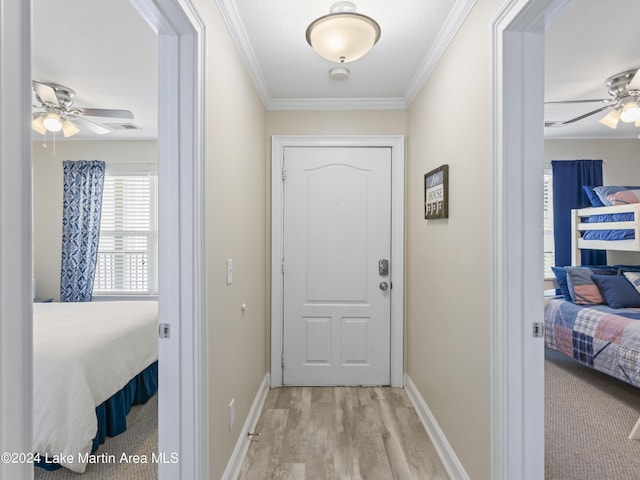 doorway featuring ceiling fan, light hardwood / wood-style floors, and ornamental molding