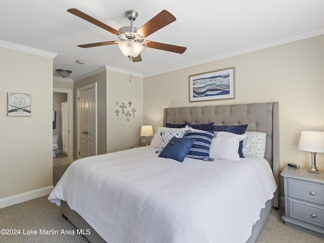 carpeted bedroom with ensuite bathroom, ceiling fan, and ornamental molding