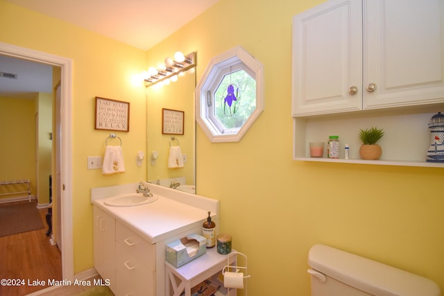 bathroom featuring hardwood / wood-style flooring, toilet, and vanity