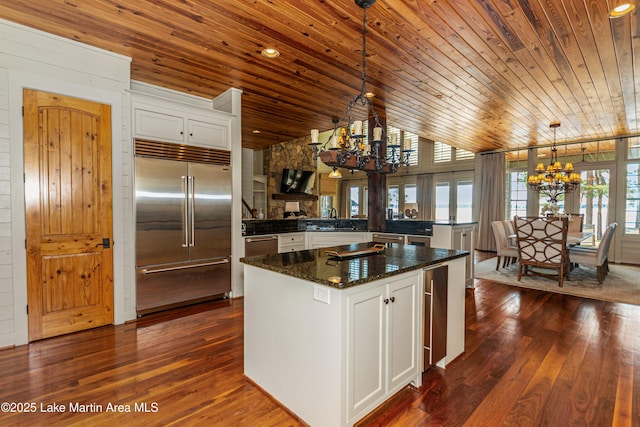 kitchen featuring white cabinetry, stainless steel appliances, decorative light fixtures, and an inviting chandelier