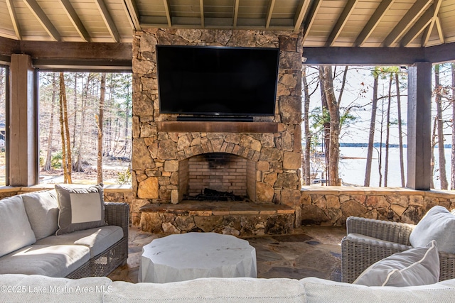 living room with vaulted ceiling with beams, a wealth of natural light, and wood ceiling