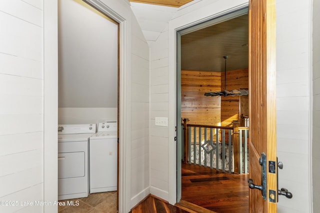 laundry area featuring washing machine and clothes dryer and wood walls