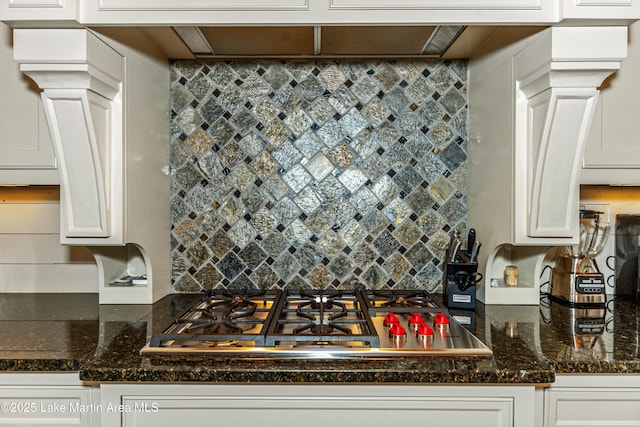 kitchen featuring stainless steel gas cooktop, white cabinets, and dark stone counters