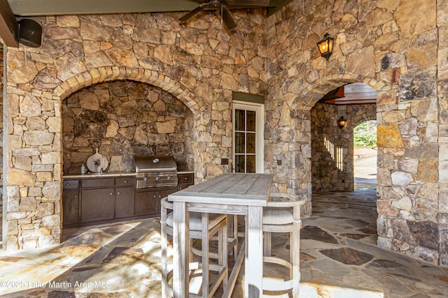 view of patio / terrace featuring grilling area, ceiling fan, and an outdoor kitchen