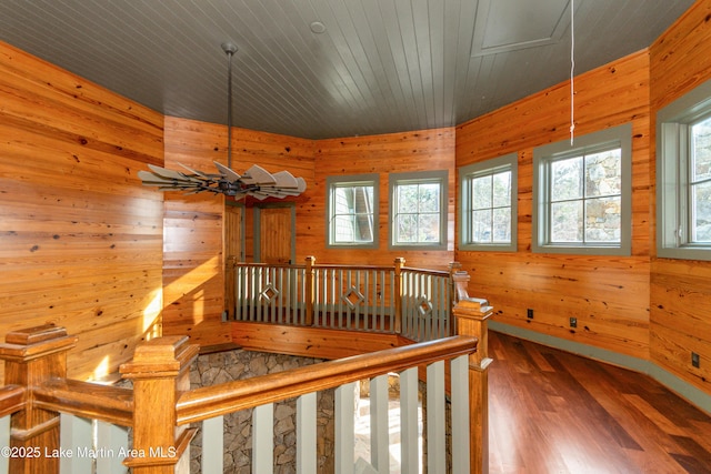 hallway featuring wooden walls, dark hardwood / wood-style floors, and wooden ceiling