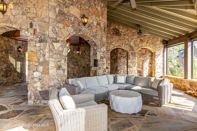 view of patio / terrace with an outdoor living space with a fireplace and ceiling fan