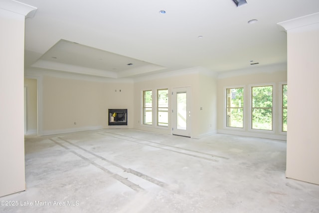 63 Noles Dr, Tallassee, AL 36078 - unfurnished living room featuring a tray ceiling, healthy amount of natural light, and a glass covered fireplace