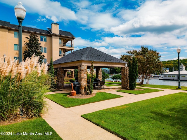 surrounding community with a gazebo, a water view, and a yard