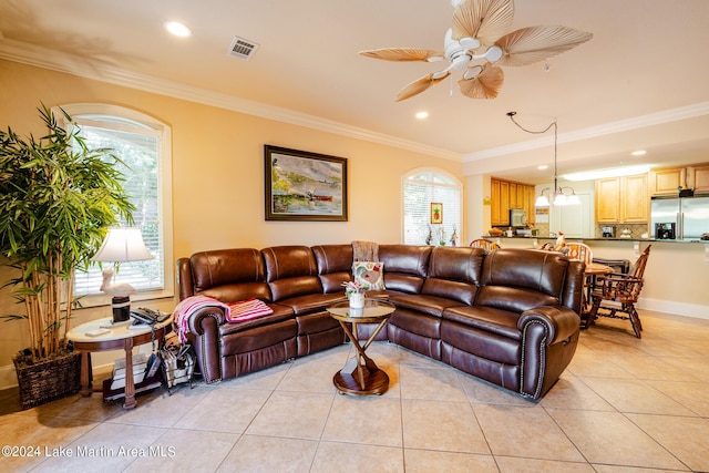 tiled living room featuring ceiling fan with notable chandelier, a wealth of natural light, and crown molding