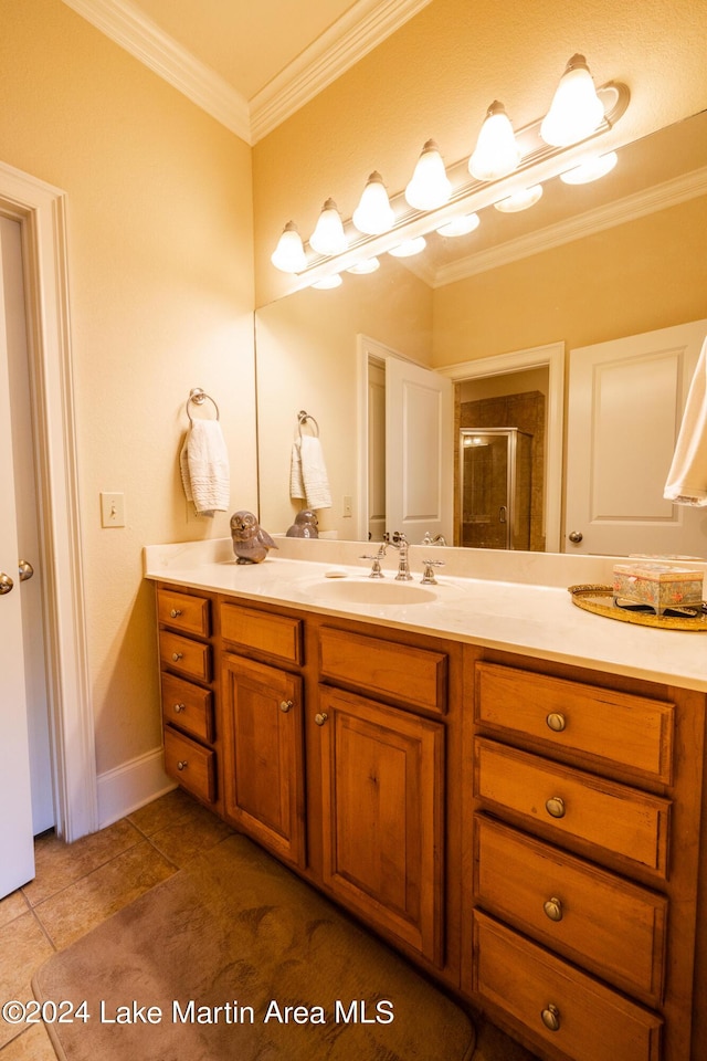 bathroom with tile patterned flooring, vanity, a shower with door, and ornamental molding