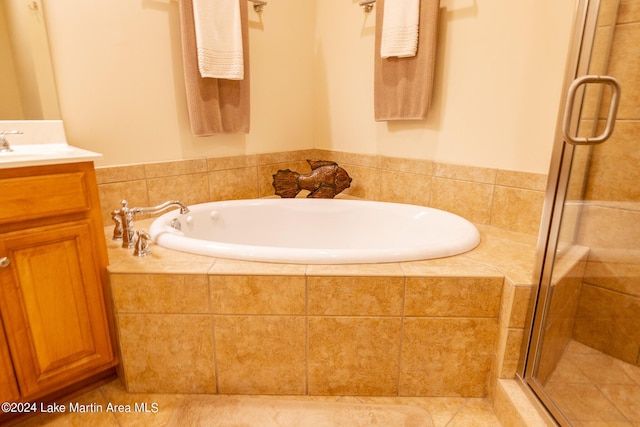 bathroom with tile patterned flooring, vanity, and separate shower and tub