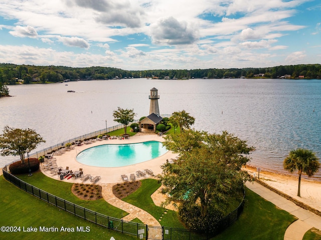 view of pool featuring a water view and a yard