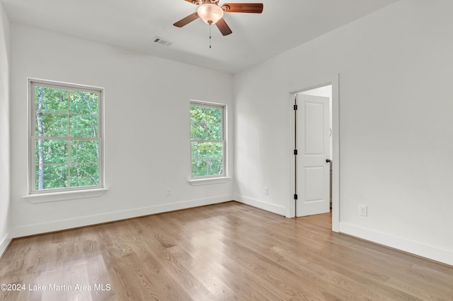 empty room with ceiling fan, a healthy amount of sunlight, and light wood-type flooring