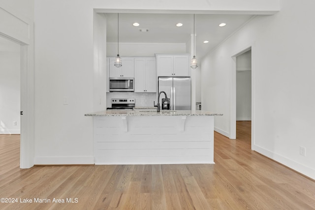 kitchen featuring stainless steel appliances, white cabinetry, light hardwood / wood-style floors, and light stone counters