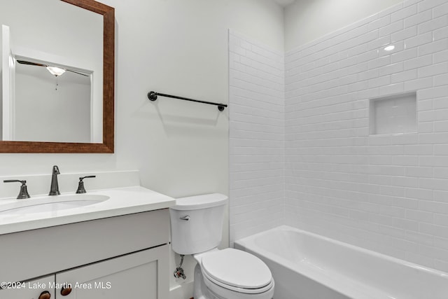 full bathroom with vanity, tiled shower / bath combo, and toilet