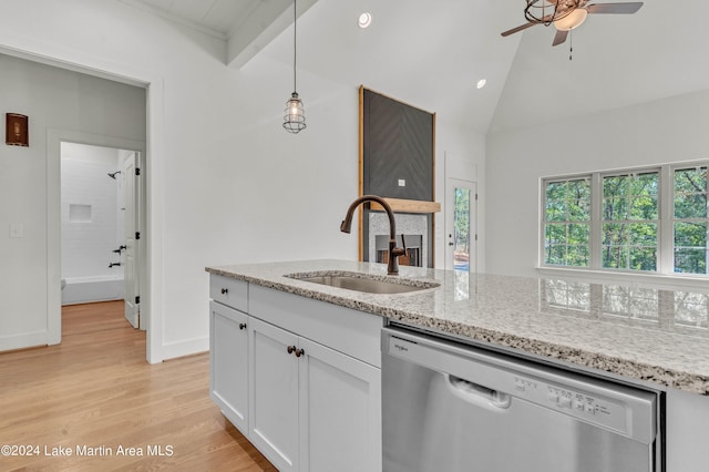 kitchen featuring white cabinetry, sink, light stone countertops, lofted ceiling with beams, and stainless steel dishwasher