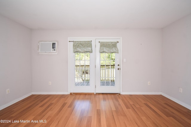 empty room featuring light wood-type flooring and a wall mounted AC