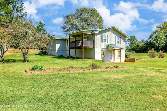 rear view of property with a lawn and a wooden deck