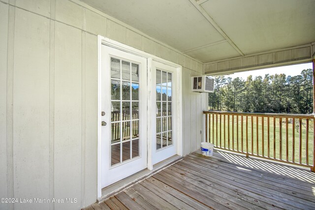 wooden terrace featuring an AC wall unit and french doors