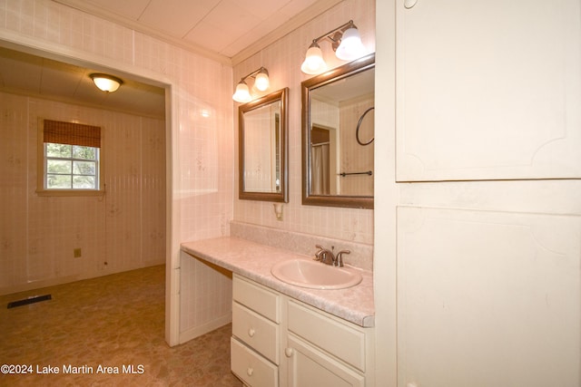 bathroom with crown molding, vanity, and tile walls