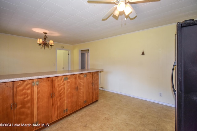 kitchen with black fridge, pendant lighting, and ceiling fan with notable chandelier