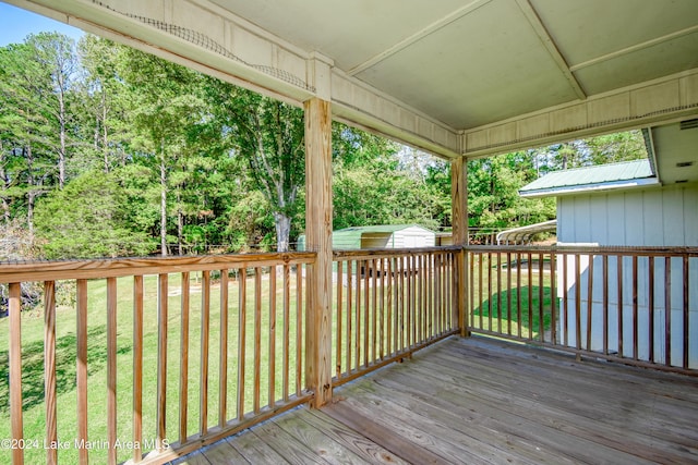 wooden terrace featuring a storage shed and a yard